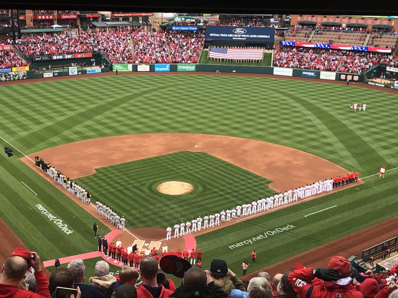 Players for the visiting Pittsburgh Pirates and the St. Louis Cardinals line the field for introductions and the playing of the National Anthem before Thursday's 2022 MLB Season Opener at Busch Stadium in St. Louis. The Cardinals won 9-0.