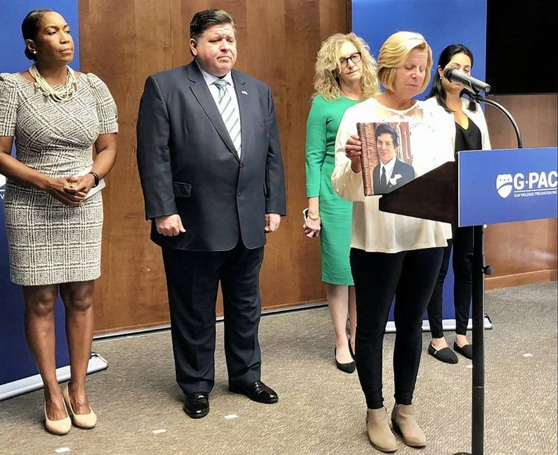 Bonnie Rich talks about the death of her son Trevor Wehner in a mass shooting in Aurora in 2019. Gov. J.B. Pritzker listens with Lt. Gov. Juliana Stratton, far left, at a campaign event Sept. 27.