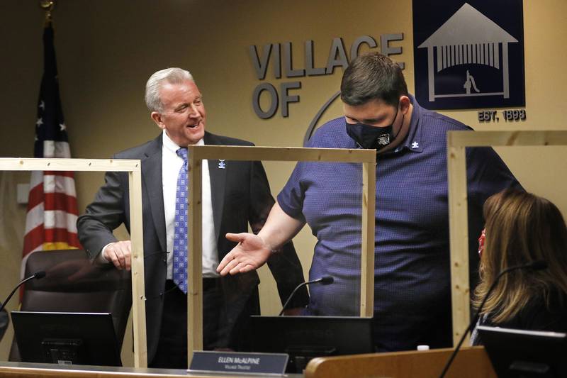 Cary Mayor Mark Kownick, left, and board member Ellen McAlpine, right, look to Danny Brezina as he prepares to take the Mayor's seat to deliver an Autism Awareness Proclamation during a board meeting at Cary Village Hall on Tuesday, April 6, 2021 in Cary.  This was the third year Brezina, a senior with autism at Cary-Grove High School, was offered the opportunity to deliver the proclamation during a village board meeting in Autism Awareness month.