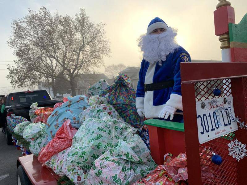Officer Santa stands on his throne in the patchy freezing fog early this morning before he delivered toys to nearly 150 La Salle children. Officer Santa, also known as a La Salle police officer Matt Kunkel, was out with other La Salle patrolman this morning delivering gifts to La Salle kids in need through donations from businesses and individuals.