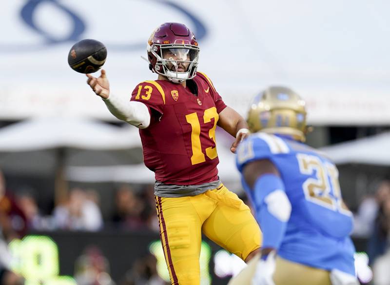 USC quarterback Caleb Williams, left, throws a pass as UCLA linebacker JonJon Vaughns watches during the second half of an NCAA college football game Saturday, Nov. 18, 2023, in Los Angeles.