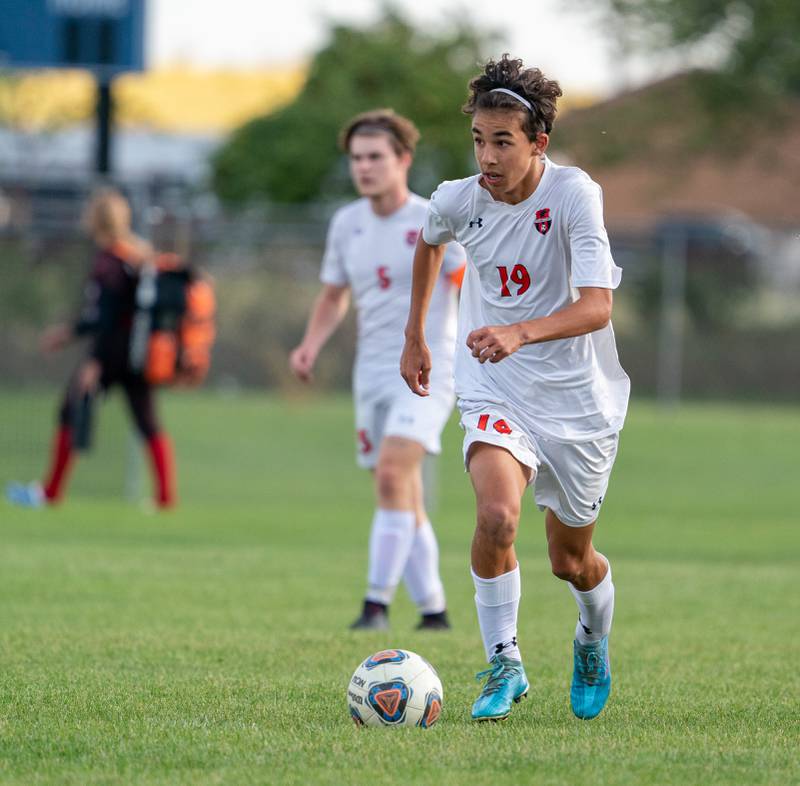 Oswego’s Lucas Ensign (19) brings the ball up the field during a soccer match against Oswego East at Oswego East High School on Monday, Sep 26, 2022.