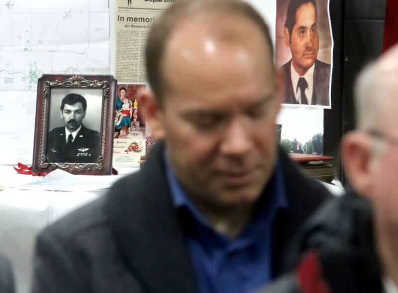 Brian Nicosia of Beverly Hills, Michigan, pauses during a moment of silence during a remembrance Saturday at Wonder Lake Fire Protection District Station 2 on the 40th anniversary of a midair military jet explosion that happened over the small, rural area northeast of Woodstock. Nicosia’s father, Co-pilot Capt. Robert J. Nicosia in the picture frame at left, and 26 others lost their lives as the plane exploded midair.