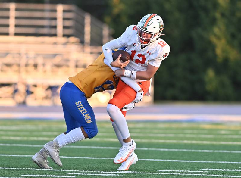 Joliet Central's Bryce Pilgrim (14) sacks Plainfield East's Brady Cloherty (12) during the conference game on Friday, SEP. 12, 2025, at Joliet.