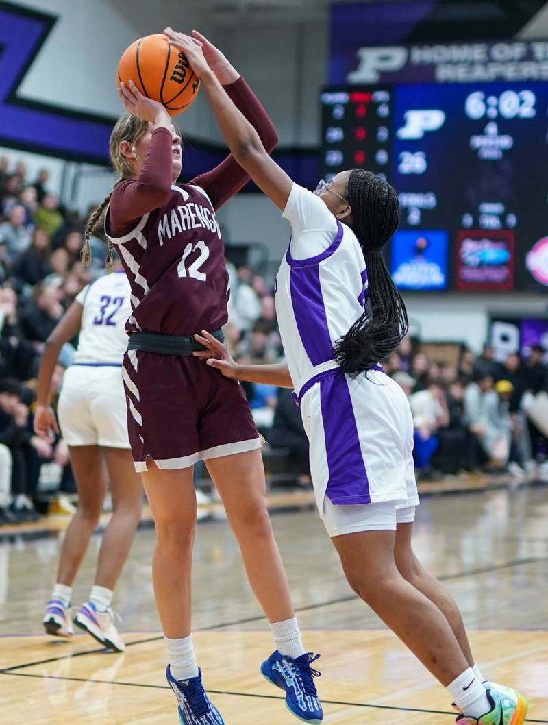 Plano's Jadyn Long (right) defends the paint blocking a shot by Marengo’s Gabby Gieseke (12) during a basketball game at Plano High School on Wednesday, January 29, 2025.