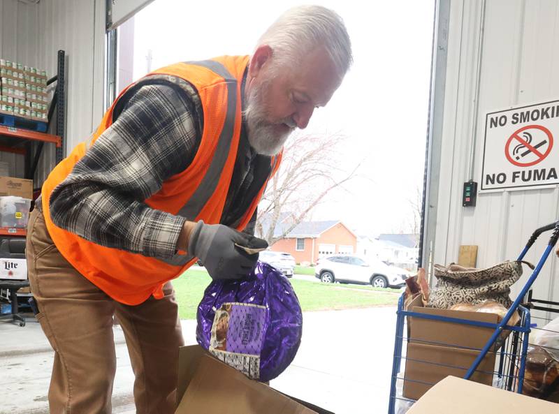 Volunteer Rob Ocepeck places a ham into a cart during the annual Easter distribution on Wednesday, April 1, 2026 at the Hall Township Food Pantry in Spring Valley.