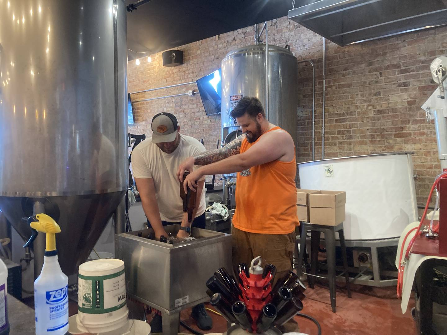 Paul Ivnik and Keven Schumacker preparing bottles for beer.