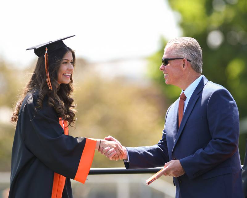 A Sandwich High School graduate receives her diploma on Sunday May 21, 2023 during the school's 139th Commencement ceremony on the school football field.