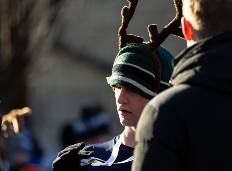 Wheaton College student Luke Roen checks out his medal after finishing the 13th annual Lions Charities Reindeer Run 5K Wheaton on Saturday, Dec. 7, 2024.
