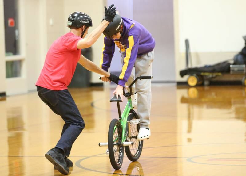 Matt Wilhelm, a national BMX Rider, Guinness World Record holder and America’s Got Talent semi-finalist helps eighth-grader Talin Irvin perform a trick during an assembly on Monday, Jan. 13, 2024 at Ladd Grade School. Wilhelm, a three-time X Games medalist and two-time national champion, is a native to Oak Lawn. Wilhelm was bullied as a child. Today, he presents a strong message while speaking to children while focusing on kindness, positivity and the differences that one person can make.