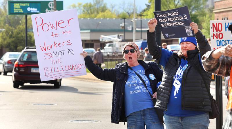 Protesters get the attention of passing vehicles May 1, 2026, during a May Day rally at Memorial Park in downtown DeKalb. The group gathered to advocate for workers’ rights and push for billionaires to be taxed amid cost-of-living burdens they argue are hurting everyday Americans.
