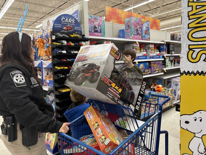 Cristina Hapanionek talks with Elijah Fish, 8, of Wonder Lake during Shop with a Cop in McHenry Dec. 8, 2024.