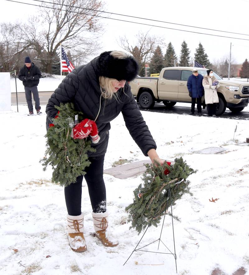 Deb LaLonde of Batavia places a wreath on the grave of John L. Nickels at St. Gall’s Cemetery in Elburn on Saturday, Dec. 17, 2022.