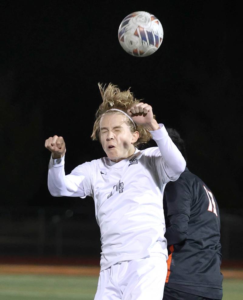 Kaneland's Wilson Love heads the ball in front of DeKalb’s Henry Garcia Alvarez during their game Thursday, Oct. 12, 2023, at DeKalb High School.