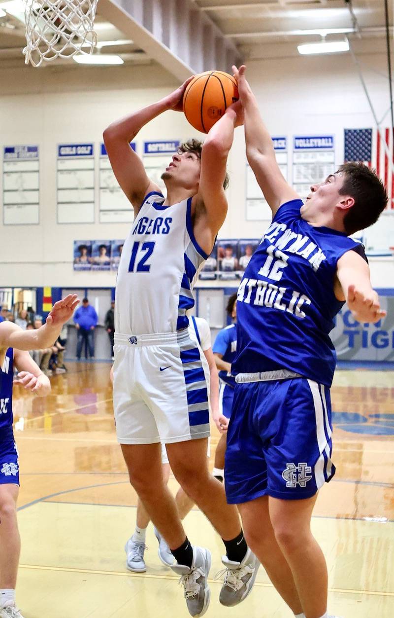 Princeton senior Asa Gartin gets by Newman's Evan Bushman on the Comets' 1-3-1 zone Friday night at Prouty Gym. Gartin scored 11 of his 13 points in the fourth quarter to spark the Tigers to a 60-46 win.