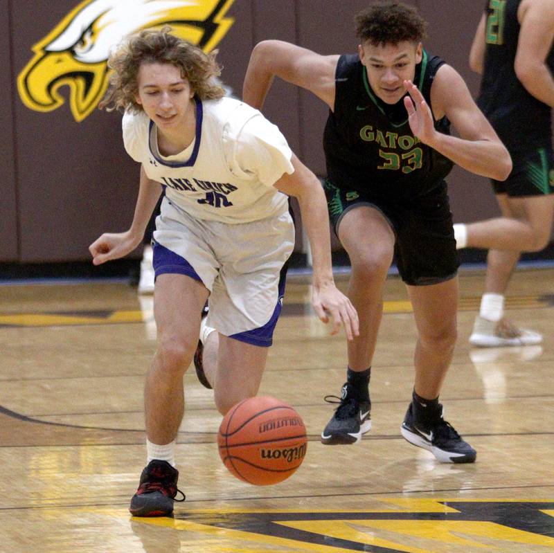 Crystal Lake South’s Cooper Buelna, right, races Lake Zurich’s Dominik Herdus for the ball in Hinkle Holiday Classic boys basketball tournament game action at Jacobs High School Wednesday.