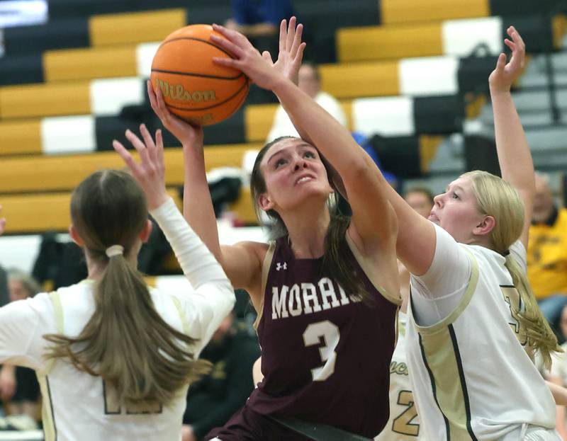 Morris' Lily Hansen goes to the basket between two Sycamore defenders during their game Tuesday, Jan. 13, 2026, at Sycamore High School.