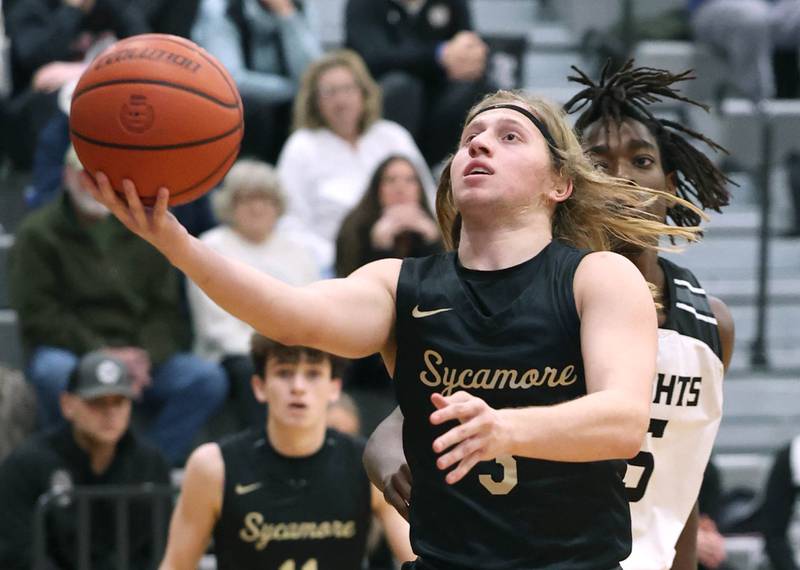 Sycamore's Carter McCormick gets to the basket ahead of Kaneland's Freddy Hassan during their game Friday, Jan. 5, 2024, at Kaneland High School in Maple Park.
