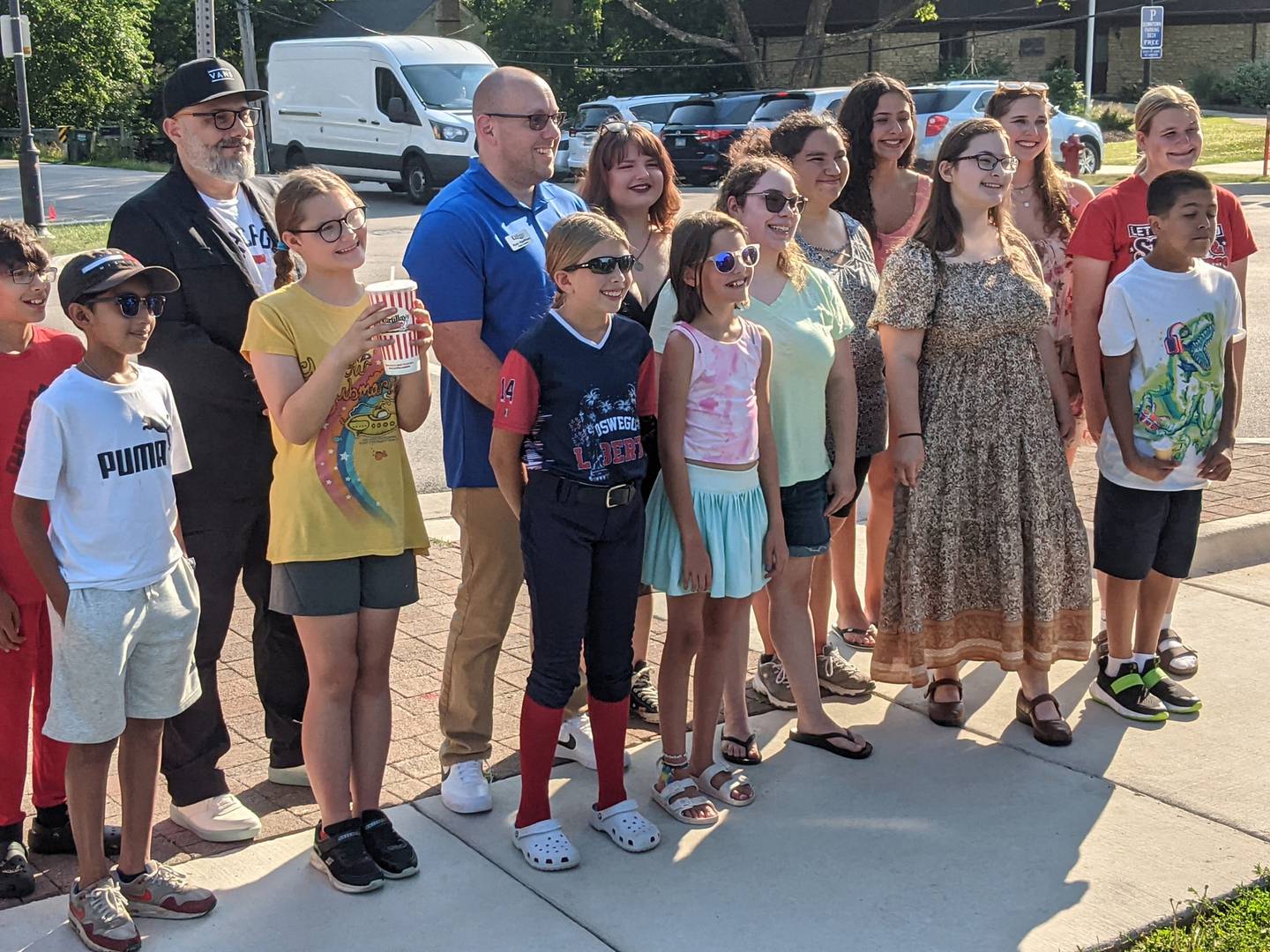 Oswego Cultural Arts Commission Chair Tony Pastore, far left, and Oswego Village President Ryan Kauffman, right, stand next to students who participated in the Look Up Oswego banner program.