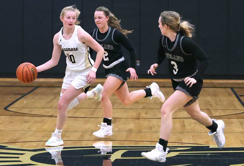 Sycamore's Lexi Carlsen pushes the ball ahead of Kaneland's Kailey Plank and Alexis Schueler during the Class 3A regional final game Friday, Feb. 17, 2023, at Sycamore High School.