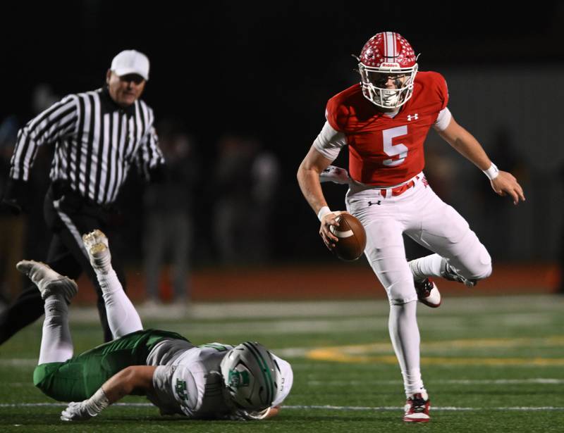 Naperville Central quarterback Sebastian Hayes, right, avoids getting sacked by York’s Tyler Hayes during the Class 8A football state semifinal on Saturday, Nov. 23, 2024 in Naperville.