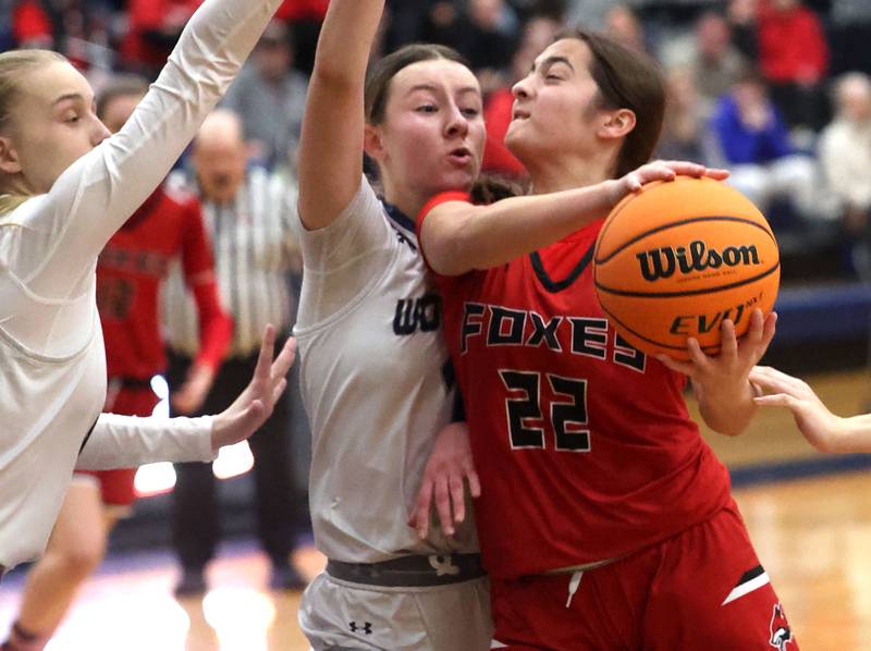 Yorkville's Sydney McCabe muscles up a shot against Oswego East's Aubrey Lamberti during their game Tuesday, Feb. 11, 2025, at Oswego East High School.