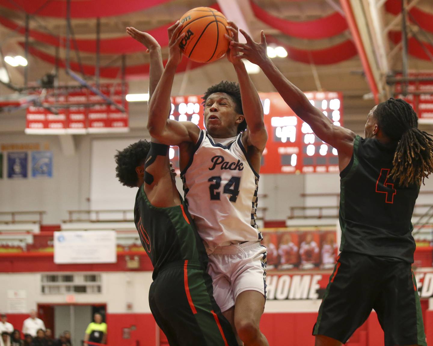 Oswego East's Dshaun Bolden (24) splits the defense on a drive to the basket during their Hinsdale Central Holiday Classic basketball game between Morgan Park at Oswego East Saturday, Dec 27, 2025 in Hinsdale.