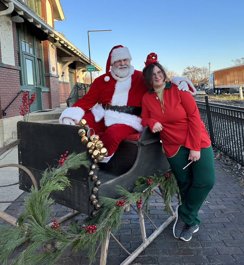 Santa posed for a photo Saturday, Nov. 25, 2023, in the 110-year-old one-horse sleigh at the Seattle Sutton Marseilles Museum. Allison Scheib also is photographed.