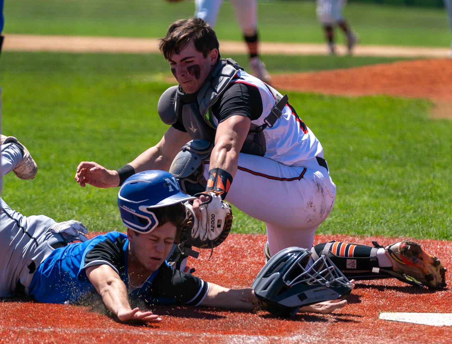 St. Charles East's Al Gaca (12) lays the tag for an out against St. Charles North's Christopher Graziano (8) during a baseball game at St. Charles East High School on Saturday, May 7, 2022.