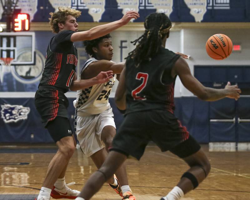 Oswego East's Dshaun Bolden (24) passes the ball off of a drive down the lane during their basketball game between Yorkville at Oswego East. Friday, Dec 19, 2025 in Oswego.