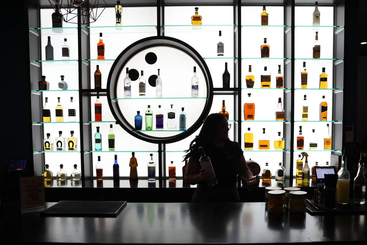 Bartender DJ Wall prepares a mixed drink in front of the wide selection of top shelf liquor at the Twisted Pin’s bar lounge area on Friday, Dec. 1, 2023 in Plainfield.