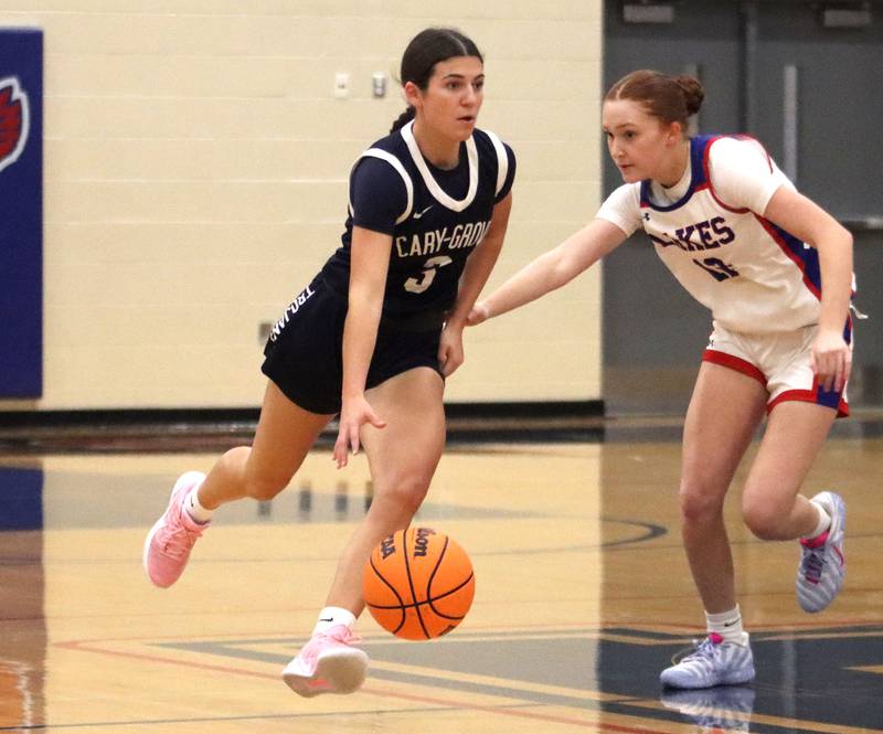 Cary-Grove’s Kennedy Manning, left, moves past Lakes’  Ryan Horvath in varsity girls basketball action on Friday, Jan. 2, 2026  at Lakes High School in Lake Villa.