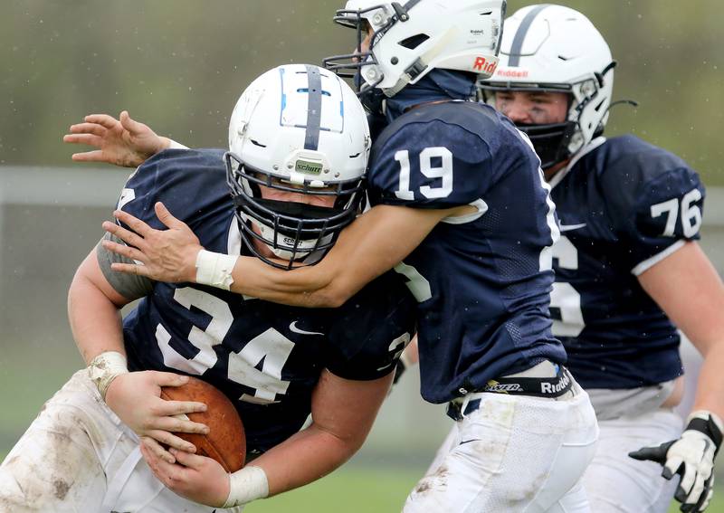 Cary-Grove's Nicholas Hissong celebrates his touchdown against Prairie Ridge with Jason Splitt, center, and Zach Stolz, right, during their football game on Saturday, April 10, 2021 at Cary-Grove High School in Cary. Cary-Grove won 20-7.