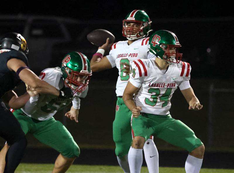 La Salle-Peru's Marion Persich gets good pass protection from Joel Lightle (left) and Easton Moriarty during their game Friday, Oct. 10, 2025, at Sycamore High School.