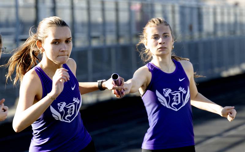 Dani Lovett takes the baton from Olivia Arduini in the 4x8 Thursday, May 8, 2025, during the girls Big Northern Conference track meet.