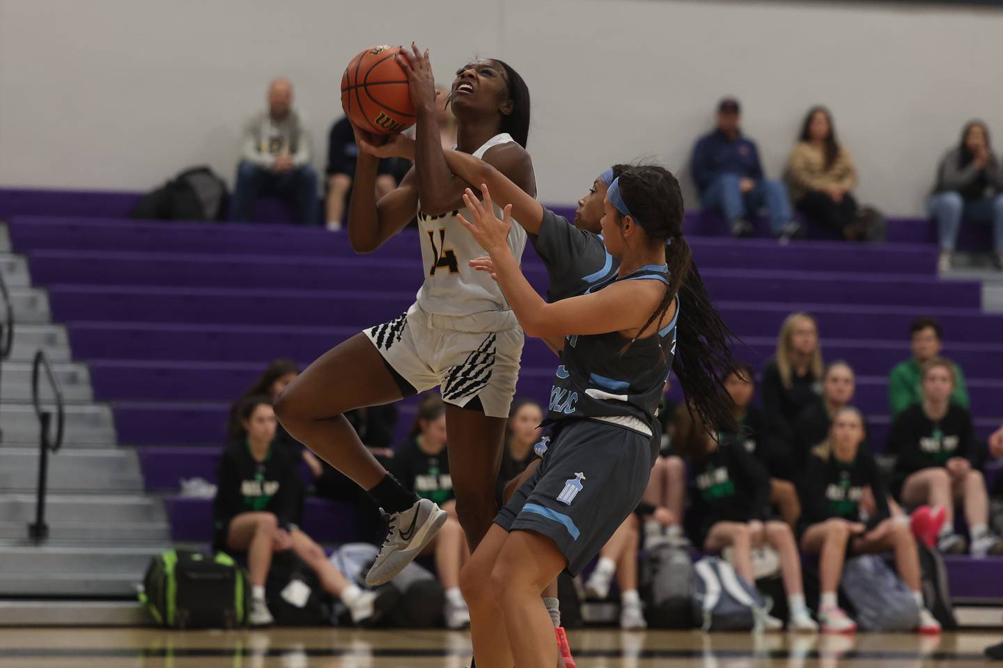 Joliet West’s Destiny McNair draws the foul going for the basket against Joliet Catholic in the WJOL Basketball Tournament at Joliet Junior College Event Center on Monday