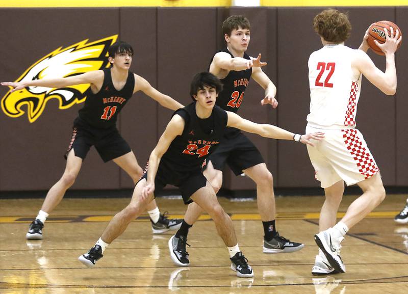 Huntley's Adam Guazzo looks to pass as he is guarded by McHenry’s Hayden Stone, from left to right, Marko Visnjevac, and Kayden Shatzer during a IHSA Class 4A Boys Regional basketball game Wednesday, Feb. 23, 2022, between Huntley and McHenry at Jacobs High School.