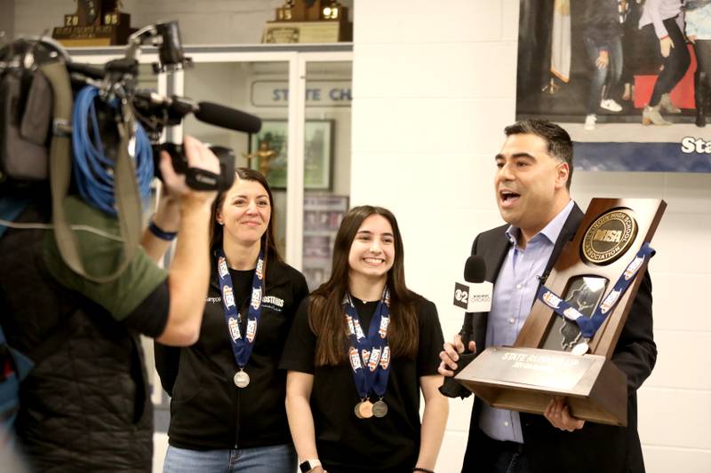 Albert Ramon, chief meteorologist for CBS2 Chicago, interviews Downers Grove South head gymnastics coach Kristyn Campos (left) and gymnast Genevieve Herion (center) as part of the television station’s day-long school spotlight coverage on Friday, Feb. 23, 2024.