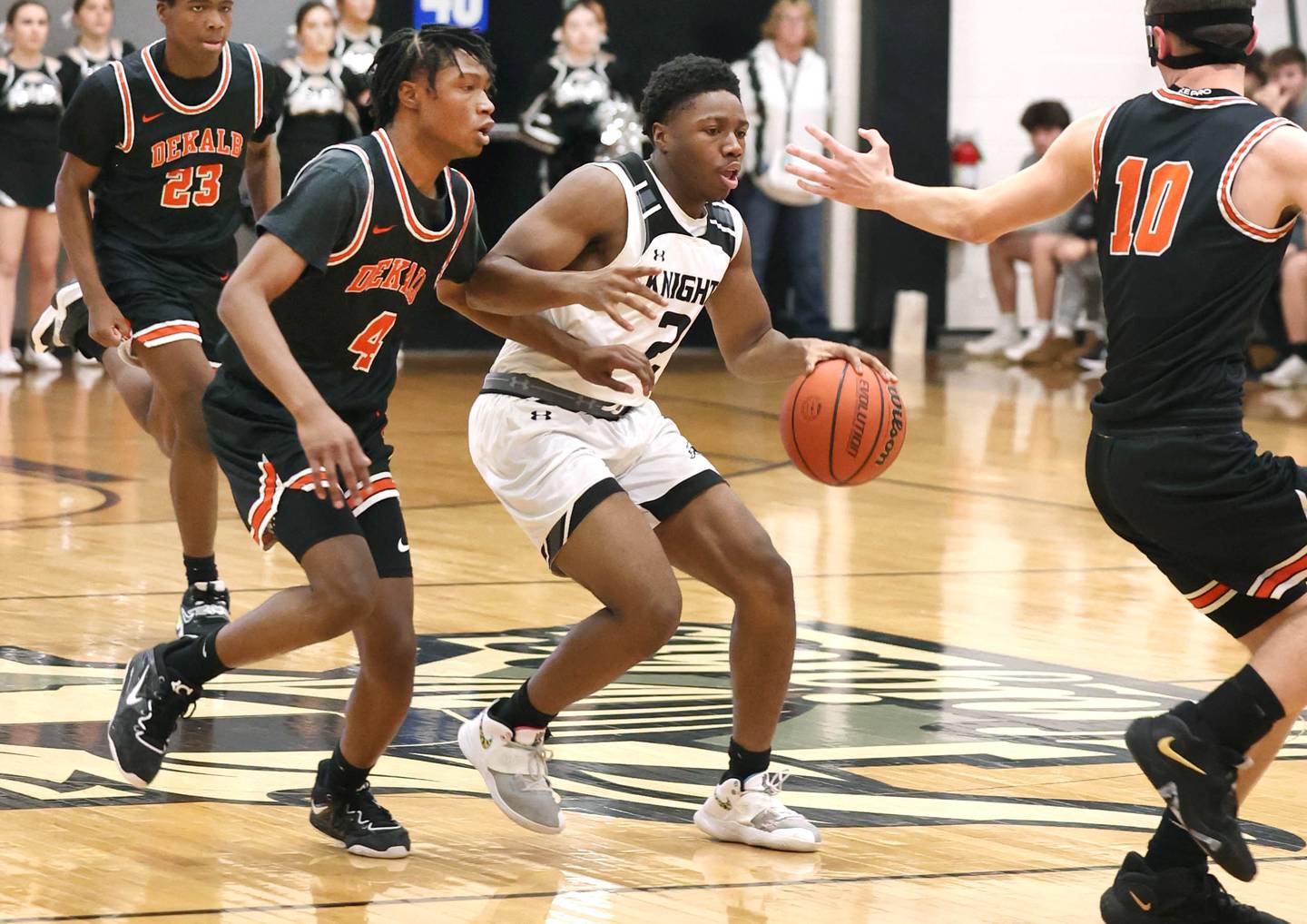 Kaneland's Gevon Grant dribbles the ball between DeKalb's Johnny Henderson and Eric Rosenow during their game Tuesday, Jan. 24, 2023, at Kaneland High School.