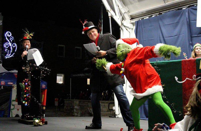 FILE PHOTO: Oswego Village President Troy Parlier grapples with the Grinch for the key, while Village Administrator Dan DiSanto looks on (left) during Oswego's Christmas tree lighting ceremony along Main Street during last year's downtown Christmas Walk event.