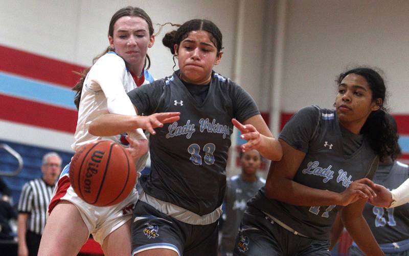 Marian Central’s Juliette Huff, left, tussles with Rockford Guilford’s Nadia Barbour, center, and Aishah Smith, right, in varsity girls basketball Saturday at Landers Pavilion on the campus of Marian Central High School in Woodstock.