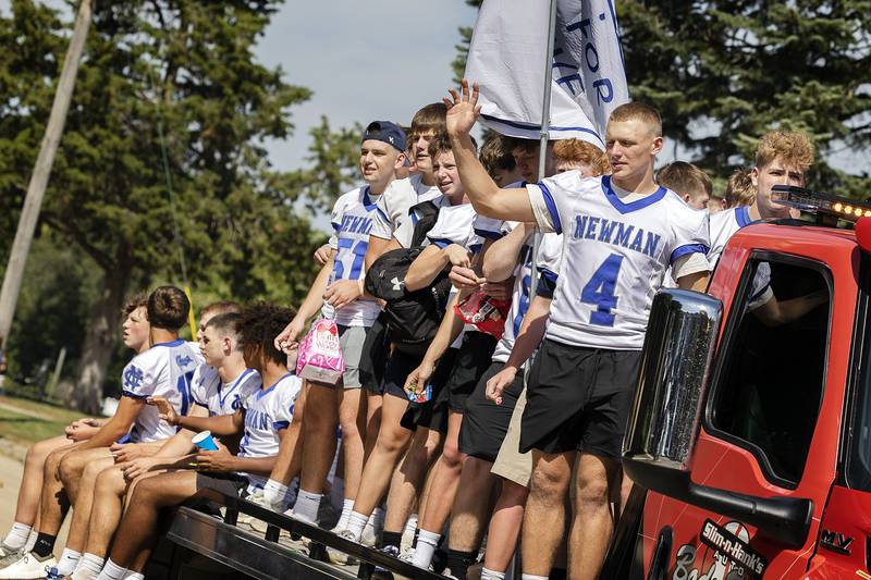 Football players wave and throw candy Friday, Sept. 12, 2025, as they roll through the Newman homecoming parade. The team will take on Erie-Prophetstown on Saturday afternoon.