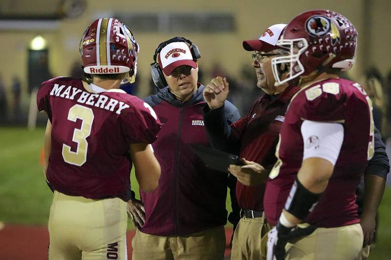 Morris quarterback Mitchell Mayberry (left) talks with coaches Greg Larsen (middle) and John Wodziak.