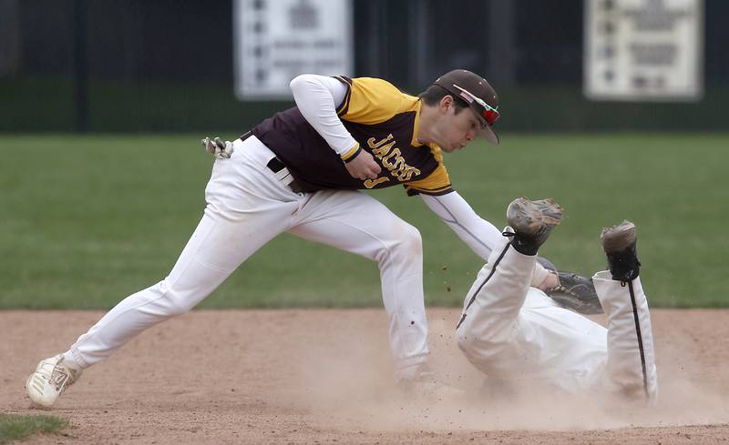 Jacobs's Drew Bennett tags out Prairie Ridge's Aidan Preves as he tries to steal second base during a Fox Valley Conference baseball game Friday, April 29, 2022, between Prairie Ridge and Jacobs at Prairie Ridge High School.