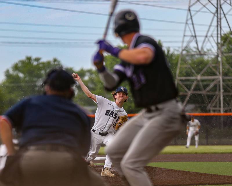 Oswego East's Patrick Flynn (12) delivers to the plate during Class 4A Romeoville Sectional semifinal between Oswego East at Downers Grove North.  May 31, 2023.
