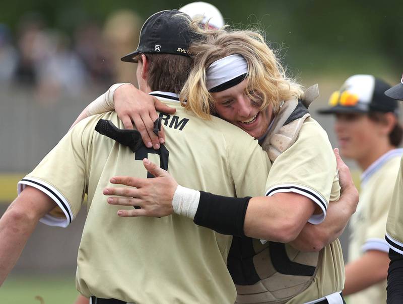 Sycamore pitcher Ethan Storm (left) and catcher Byron Blaise hug after the final out is recorded to beat Kaneland Saturday, June 4, 2022, and win the IHSA Class 3A Sectional final game at the Sycamore Community Sports Complex.