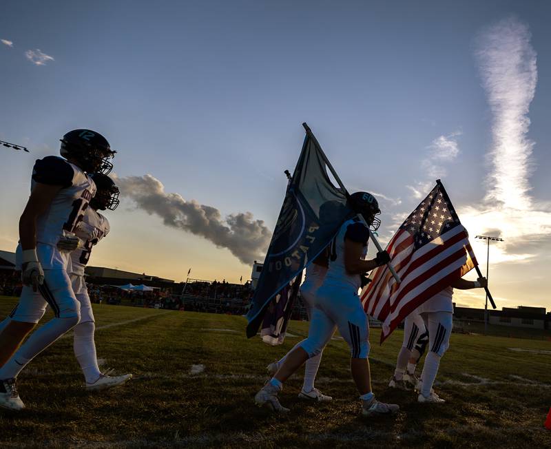 The 2023 Dixon Dukes football team comes onto the field for their season opener in Stillman Valley Friday, August 25, 2023.