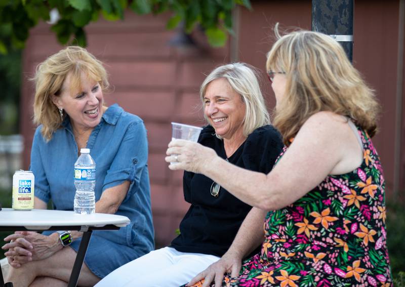 Kate Jaskowiak, left, Cindy Dayton, middle, and Judy schier converse during Thirsty Thursday on the Deck at the Lake Ellyn Boathouse in Glen Ellyn on July 20, 2023.