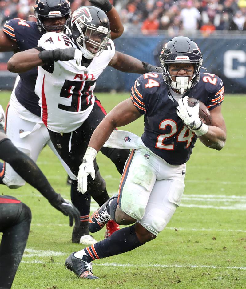 Chicago Bears running back Khalil Herbert runs away from Atlanta Falcons defensive end Zach Harrison during their game Sunday, Dec. 31, 2023, at Soldier Field in Chicago.