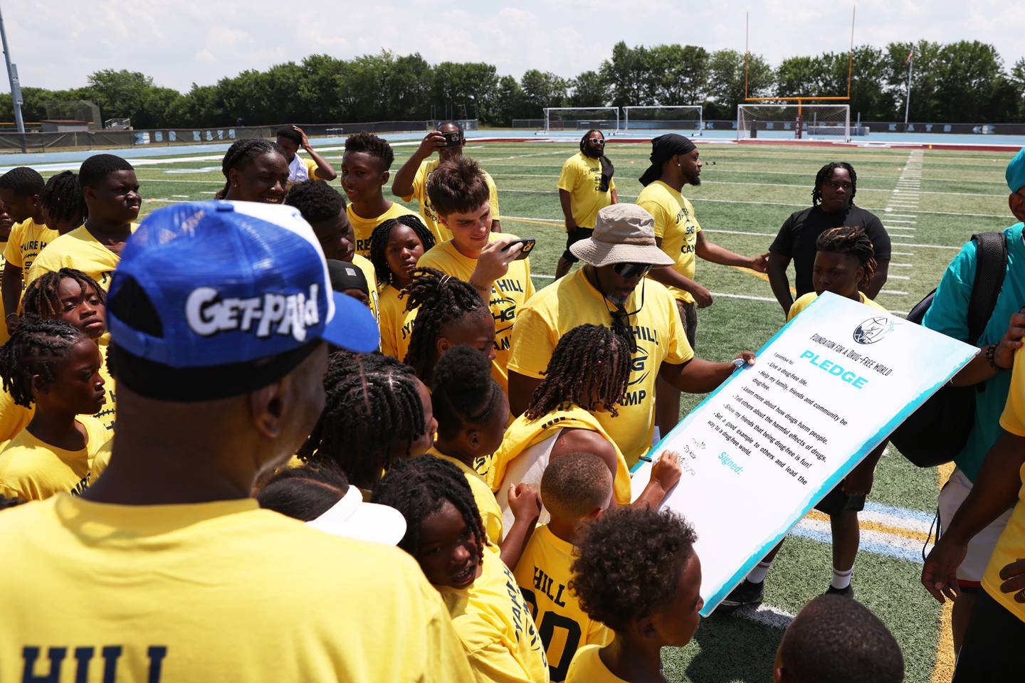 Campers gather to sign a drug-free pledge from the Foundation of a Drug Free World during Jyaire Hill's Suga Summer Camp at Kankakee High School on Saturday, July 5, 2025.
